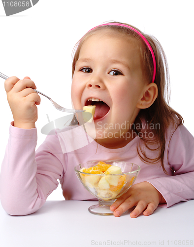 Image of Little girl eats fruit salad