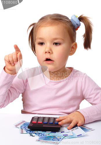 Image of Little girl plays with money