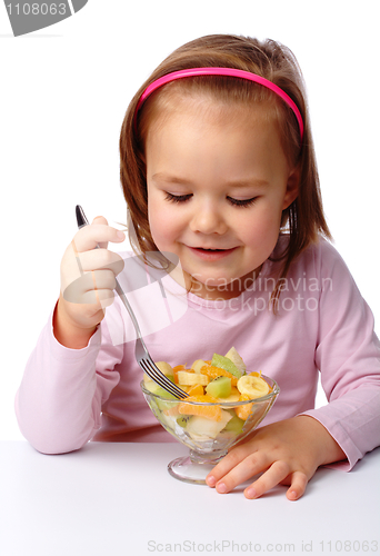 Image of Little girl eats fruit salad