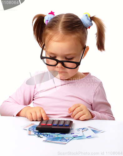 Image of Little girl plays with money