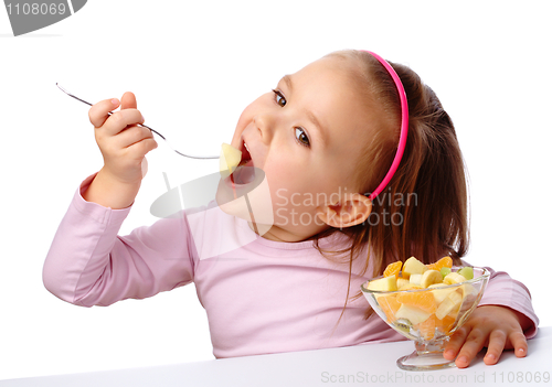 Image of Little girl eats fruit salad