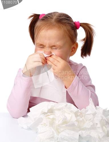 Image of Little girl blows her nose