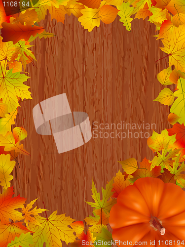 Image of Fall leaves and pumpkins on wood background.