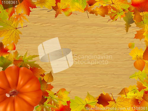 Image of Fall leaves and pumpkins on wood background.