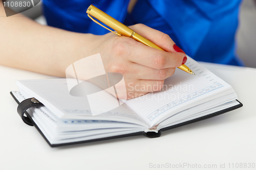 Image of She takes notes in notebook