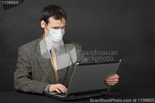 Image of Person with medical mask working in Internet