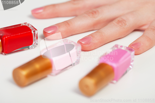 Image of Women's hand and three bottles nail polish