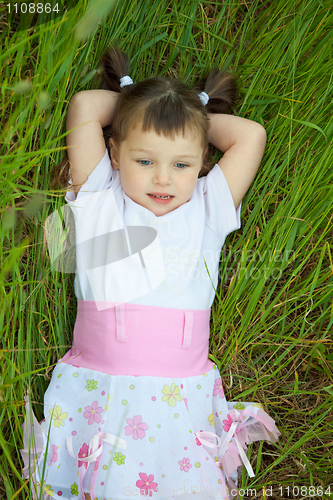 Image of Little girl has rest in grass