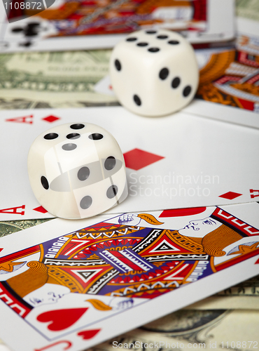 Image of Dice against of playing cards and money