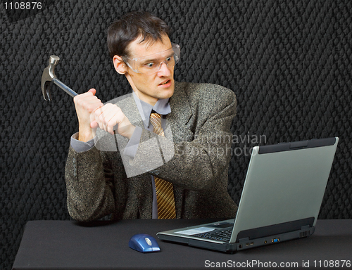 Image of Comical person intends to break computer with hammer