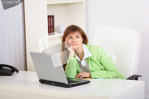 Image of Dreamy woman in office