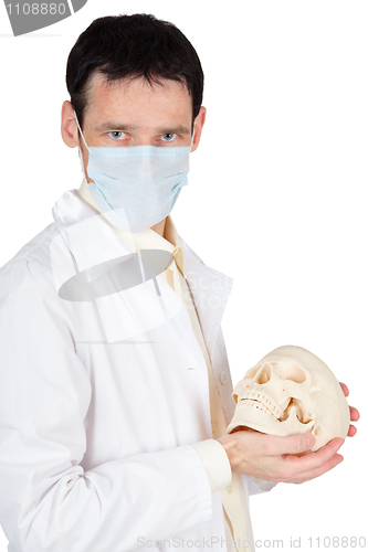 Image of Young doctor in medical mask with a skull