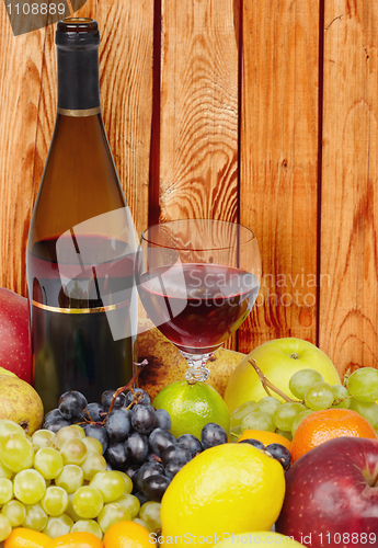 Image of Wine and fruits on background of wooden wall