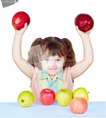 Image of Girl playing with apples sitting at table