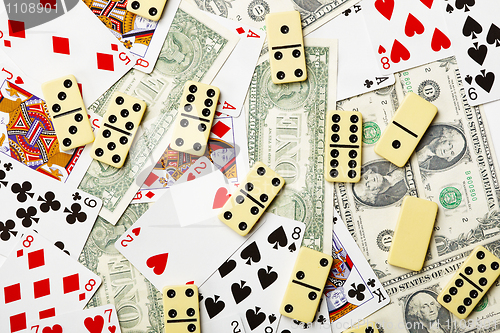 Image of Dominoes are scattered on cards and money