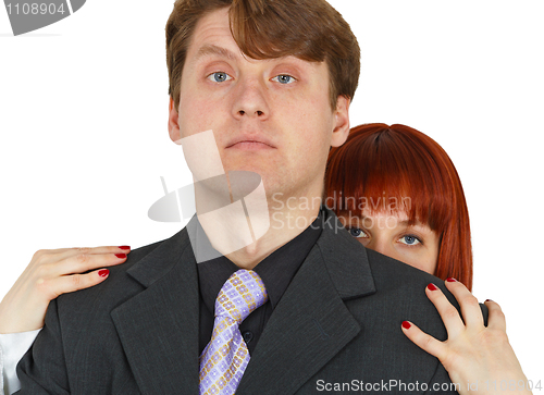 Image of Young woman hides behind big shoulders of man