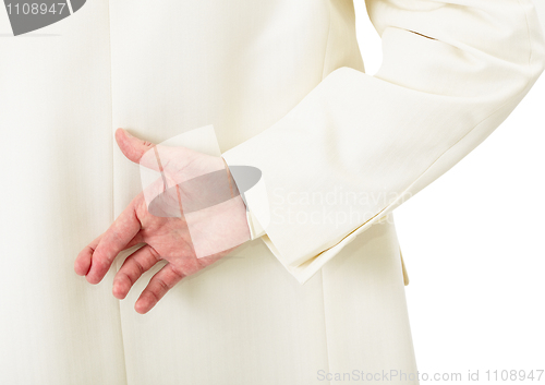 Image of Businessman in white suit with crossed fingers