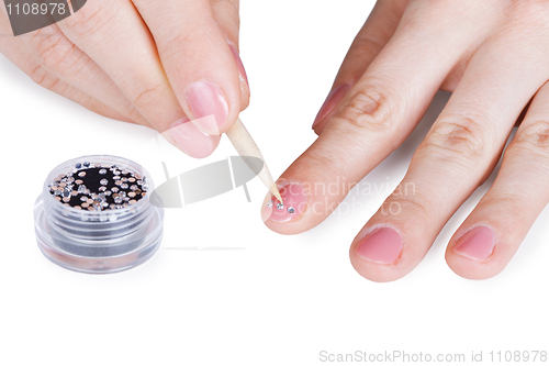Image of Female hands. Gluing a paste on nail.