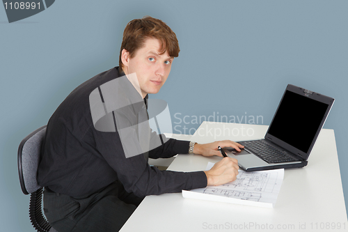 Image of Young specialist working on project in office