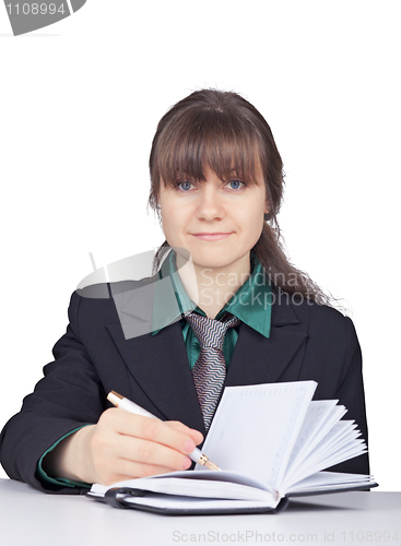 Image of Young woman - student does records in notebook