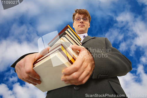 Image of Man with big stack of books against sky