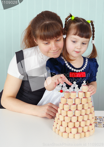 Image of Mother and daughter play sitting at table