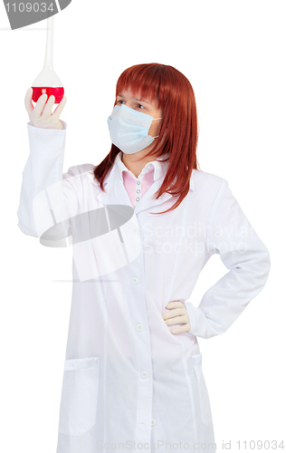 Image of Woman - scientist analyzes color of solution in flask