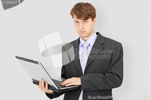 Image of Business man with laptop on grey background