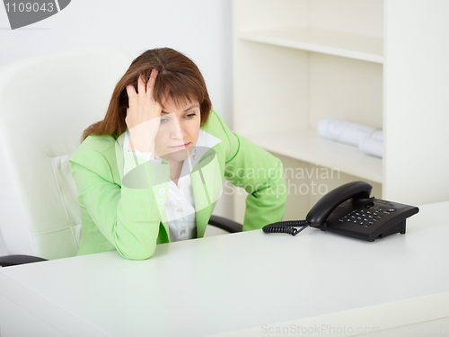 Image of A sad young woman in office at workplace