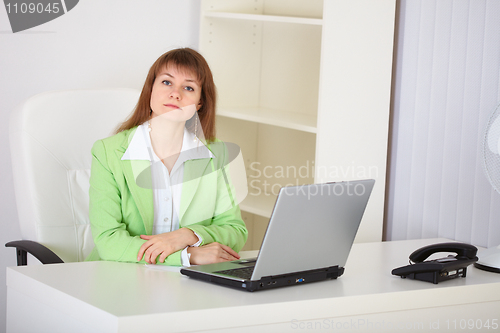 Image of Woman - chief seriously looks at us sitting on workplace