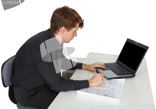 Image of Man is working while sitting at desk