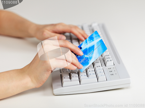 Image of Hands with plastic credit card on computer keyboard