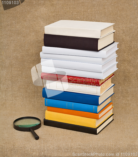 Image of Pile of books and magnifying glass - Educational still life