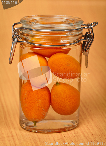 Image of Kumquat in small tin can on wooden background