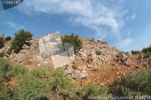 Image of Round rocky hill with green bushes