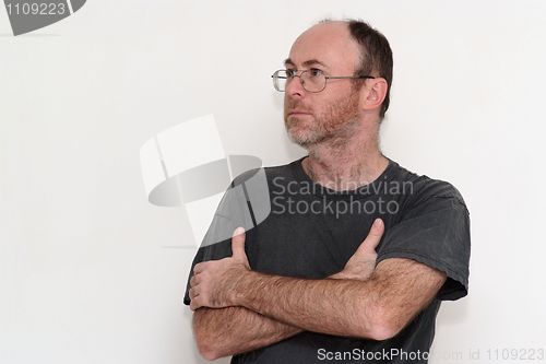 Image of Unshaved disheveled man in spectacles frowning 