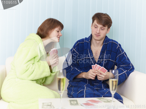 Image of Couple play cards sitting on sofa