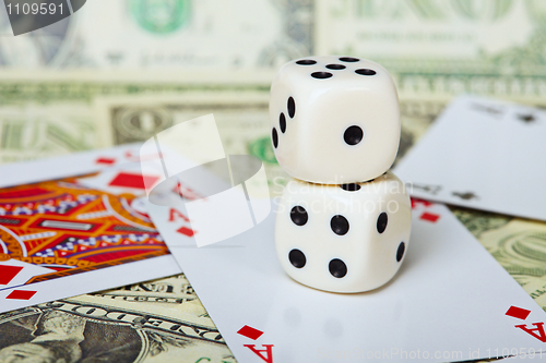 Image of Pair of dice on background of cards and money