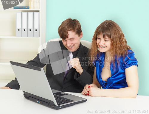 Image of Happy people looking at laptop screen