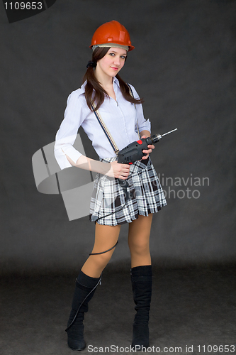 Image of Girl - teenager posing with an electric drill