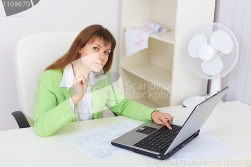 Image of Funny girl working with laptop in office