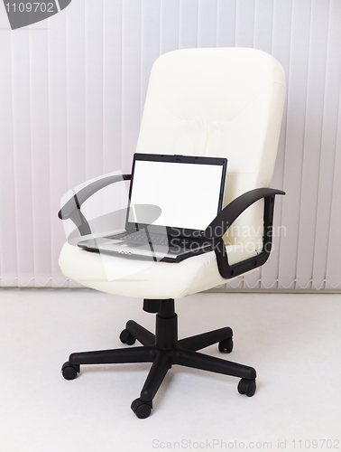 Image of Laptop sits in leather chair for manager