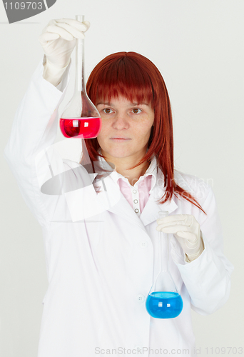 Image of Woman chemist with colored flasks