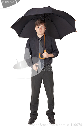 Image of Serious man in black clothes with an umbrella