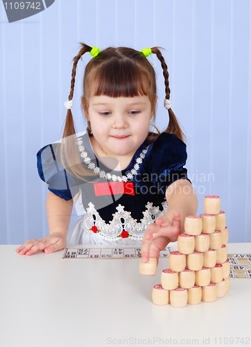 Image of Little girl playing with toys on table