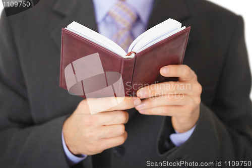 Image of Man reads entries in notebook - close-up