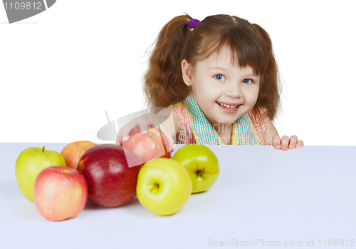 Image of Little cheerful girl with apples