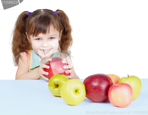 Image of Little girl playing with fruits sitting at table
