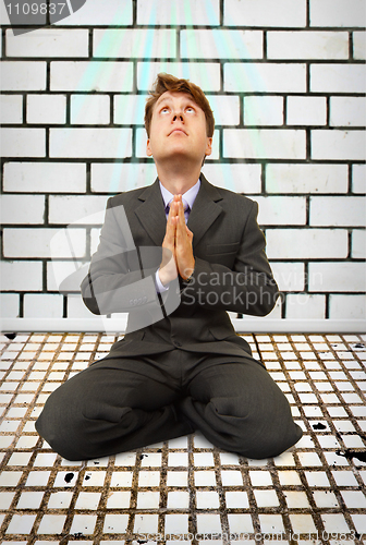 Image of Comic businessman on knees praying