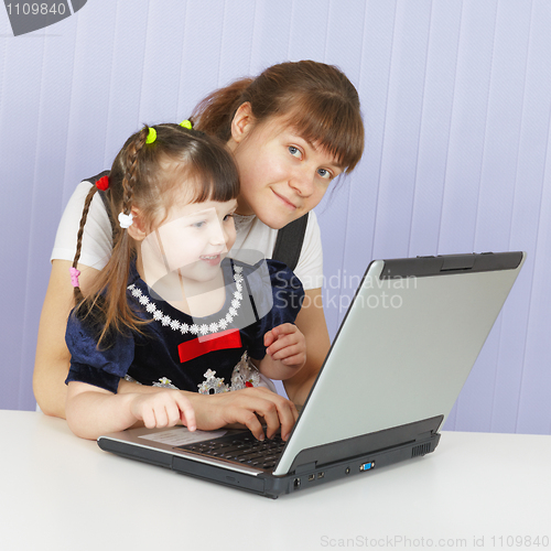 Image of Mother and daughter playing with a computer at home